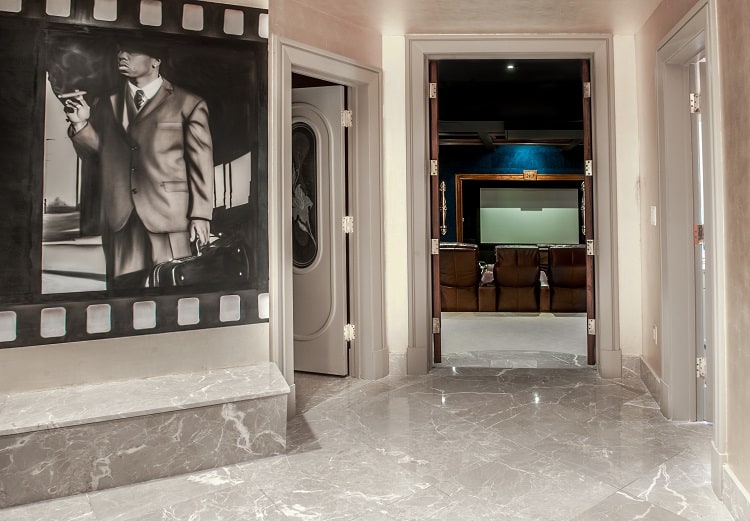 hallway with artwork leading to the home theater