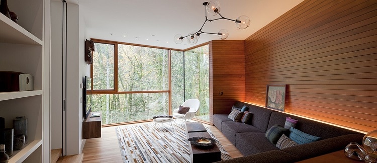 living area of the Hoke House, the original Twilight house, with a black sofa set against a wooden wall
