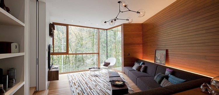 living area of the Hoke House, the original Twilight house, with a black sofa set against a wooden wall 