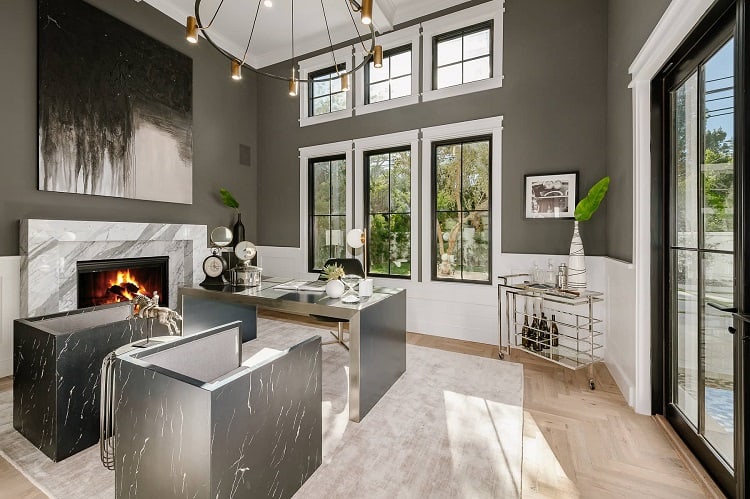 elegant home office with chrome furniture, a marble fireplace and an interesting chandelier