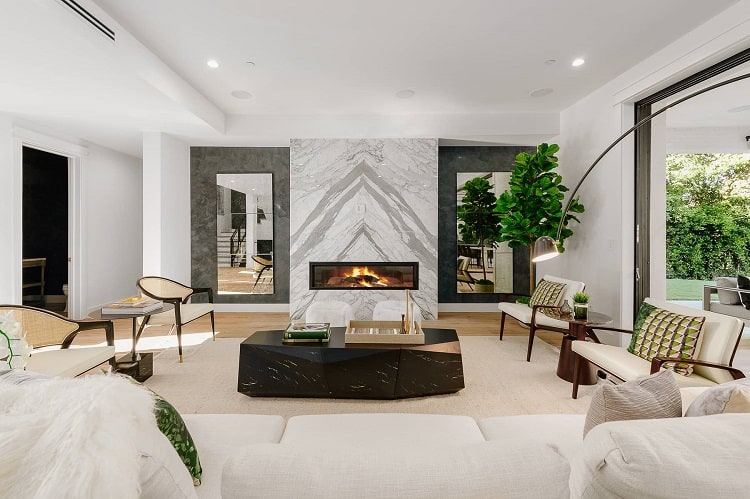 luxury living room with a grey marble fireplace and cream-colored chairs and sofa