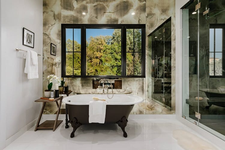 moody bathroom with a black-and-white clawfoot tub and a walk-in shower with a large window