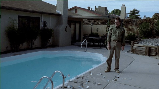 Walter White next to the pool of the Breaking Bad house, staring at dollar bills thrown on the ground