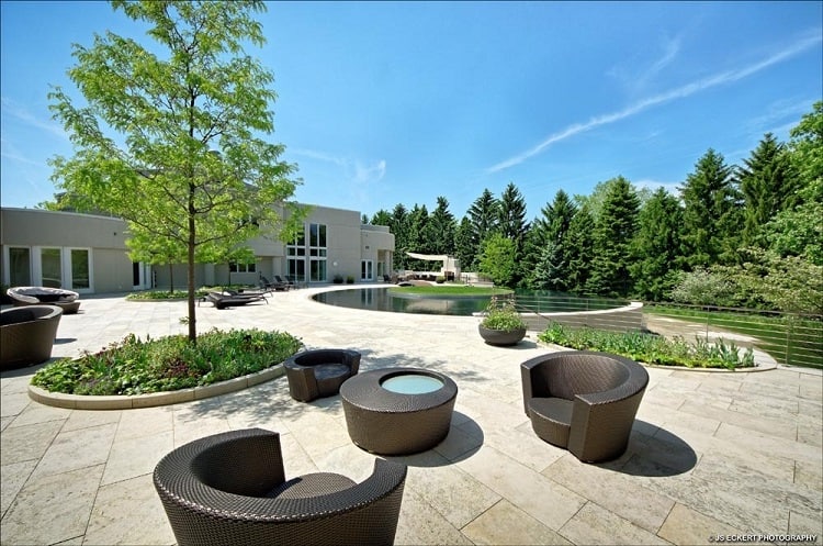 Backyard area with a circular pool, seating and plenty of greenery.