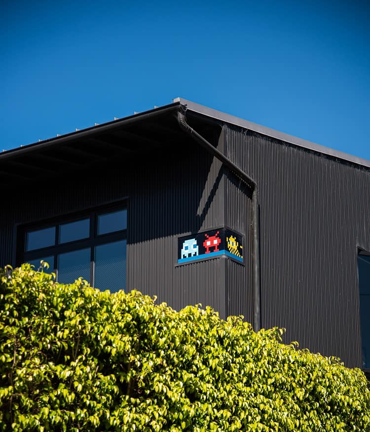 exterior of a warehouse-like home in Venica, CA with artwork by french artist Invader.