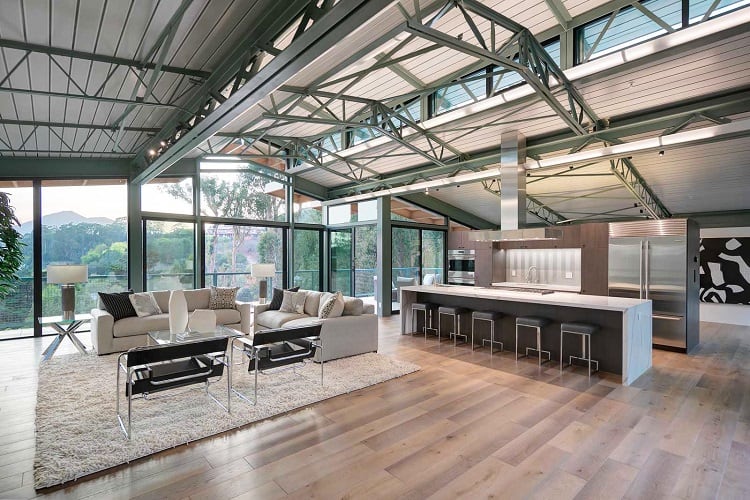 The house boasts a modern industrial design with soaring steel beamed ceilings. 