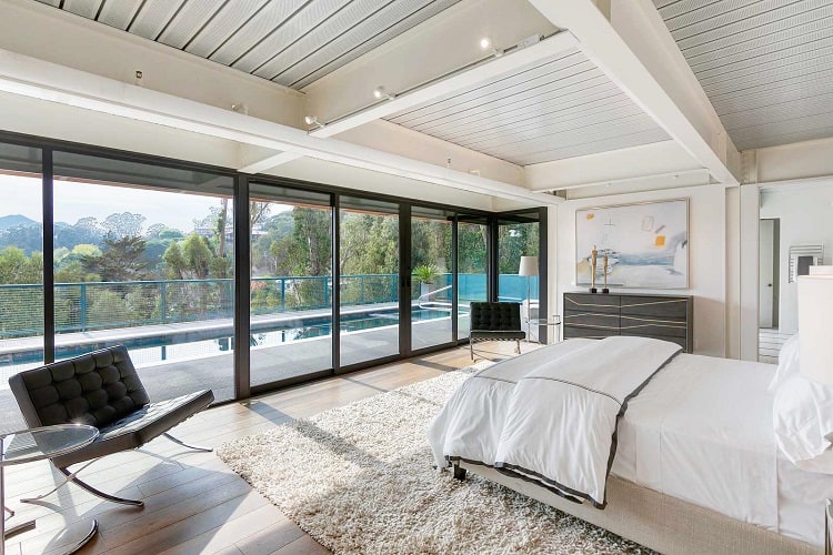 modern bedroom with glass walls overlooking the pool