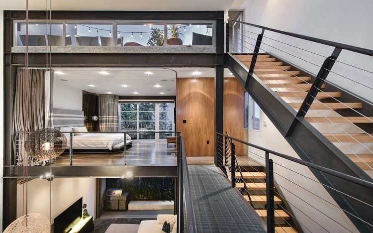 The two-story loft's bedrooms are suspended over the living room