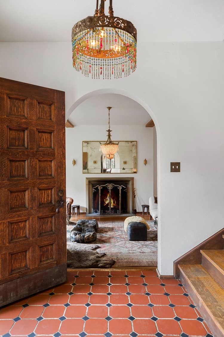 The foyer leads into the formal living room, which has its original stone wood-burning fireplace.