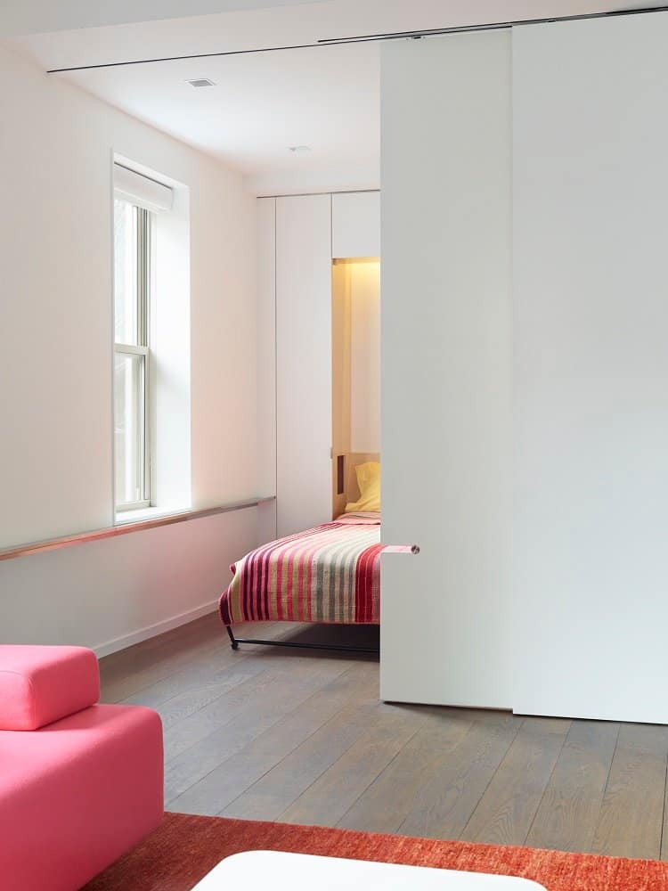 the dining room of this NYC apartment turns into a bedroom with a murphy bed and sliding doors