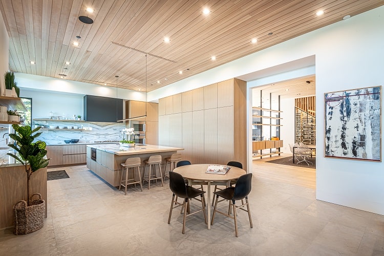 The wood-clad kitchen has practical cabinets that conceal the refrigerator for a cohesive design