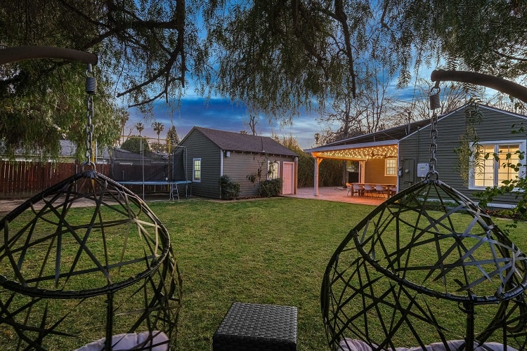 beautiful large backyard with a pergola lit by string lights