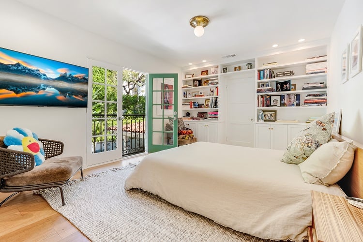 secondary bedroom with balcony and built-in bookshelves