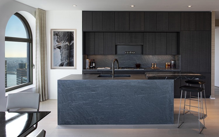 luxury kitchen with dark wood cabinets and dark concrete kitchen island