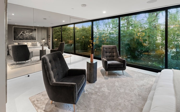 A glass-clad wall in the main bedroom masks a walk-in closet and reflects the outdoor views.