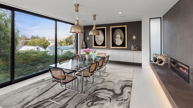 luxury dining room with walls of glass and a dual-sided fireplace