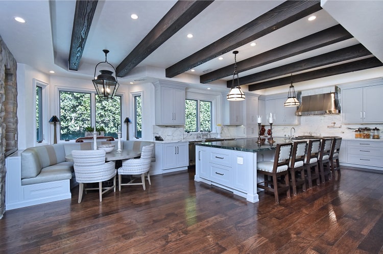 luxury white kitchen with warm wood floors, wooden beams and a lovely breakfast nook