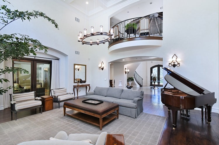 majestic two-story living room with a piano and balcony