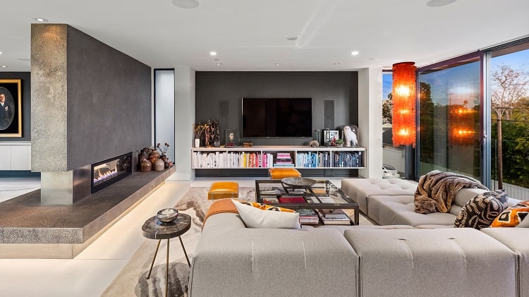 luxurious modern living room with a floor-to-ceiling fireplace dividing the open floor plan