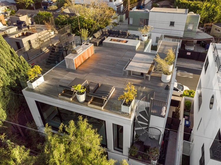 The deck is surrounded by glass walls, offering wraparound views of the city and ocean nearby.