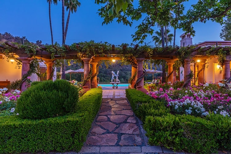 ivy-covered arches leading to the pool in a luxury estate