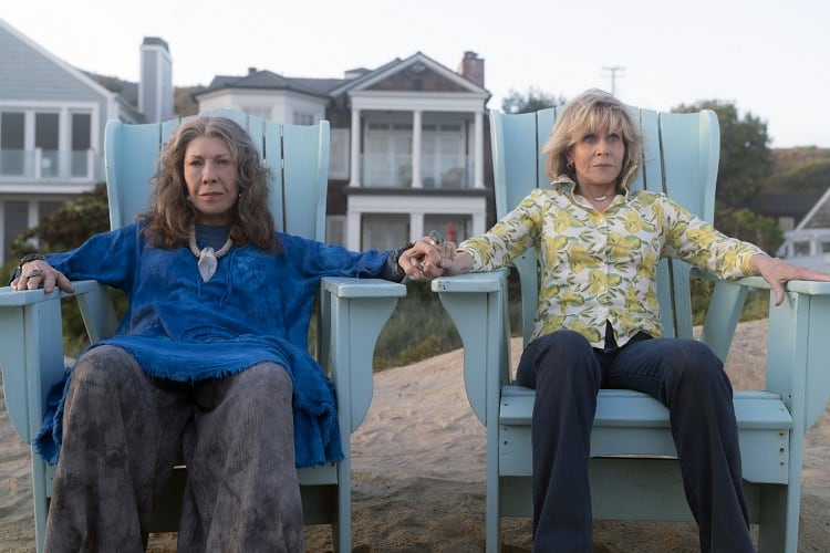 grace and frankie in front of their beach house