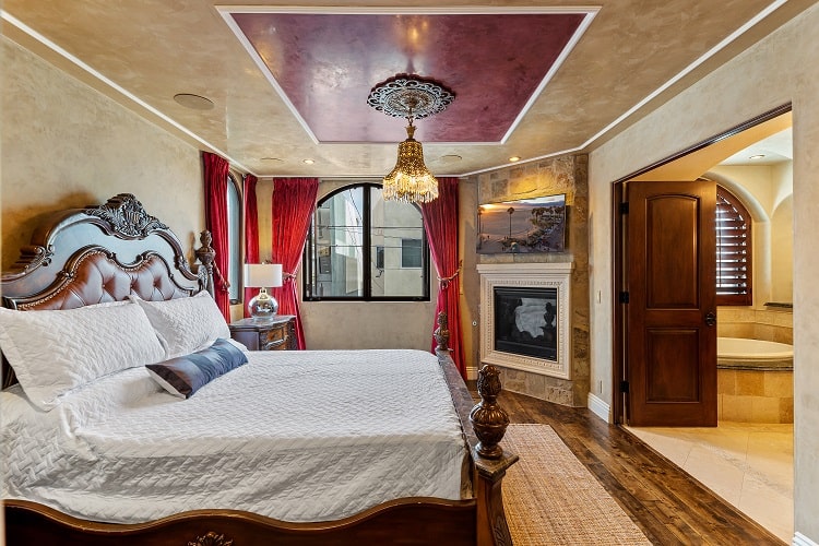 opulent bedroom with sophisticated decor, a fireplace and a chandelier