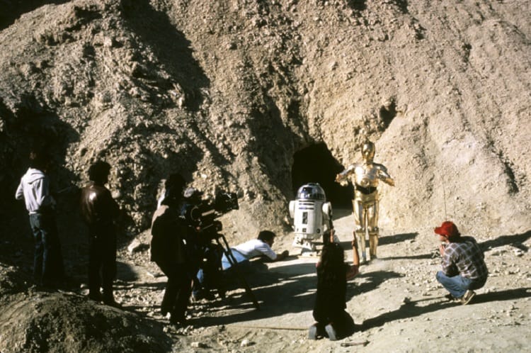 The production crew filming a Star Wars scene in Death Valley, California. R2D2 and C3PO pictured, surrounded by a desert-like environment