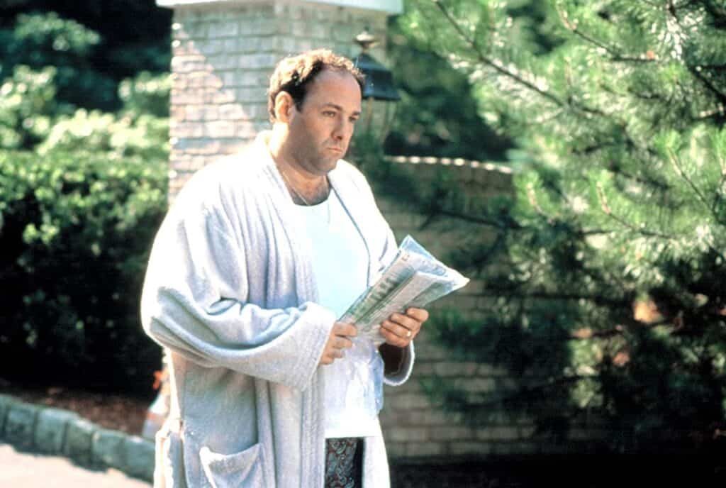 tony soprano picking up his morning paper on the driveway of his house in New Jersey