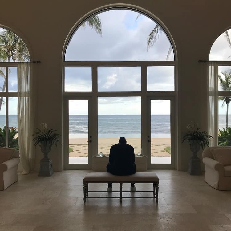 Still shot from the Netflix documentary The Last Dance, with Michael Jordan standing on a bench, back to the camera, looking out through tall windows overlooking the water. 