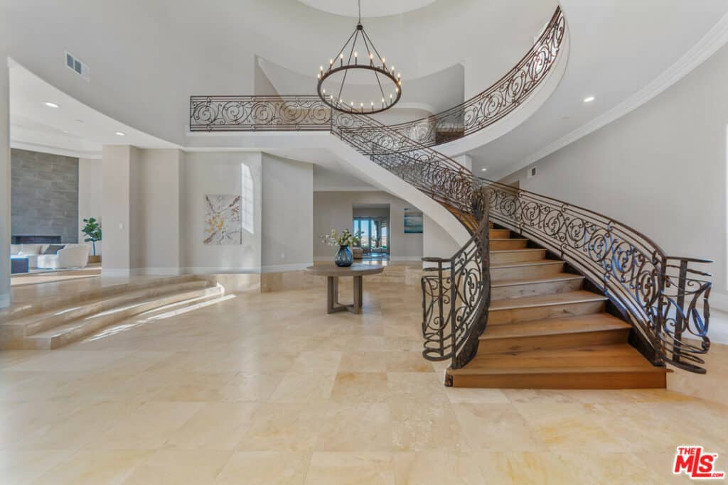 The sprawling property is the definition of luxury, with a winding staircase anchoring the lower level