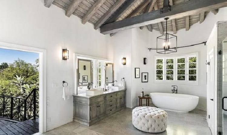 The primary bathroom inside Selena Gomez's house, with a freestanding bathtub underneath a beamed wood ceiling