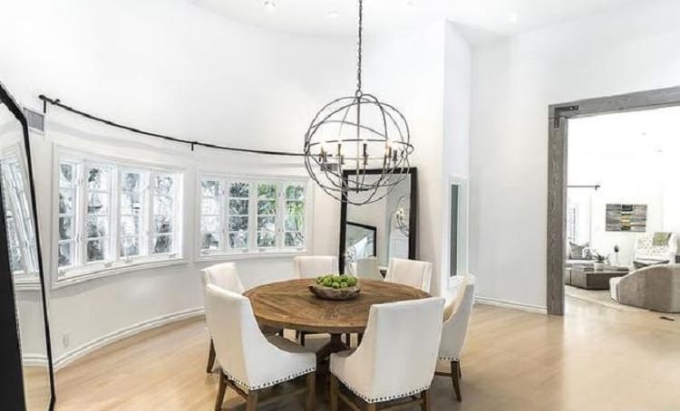 dining area inside the kitchen, with a round table underneath a circular light fixture