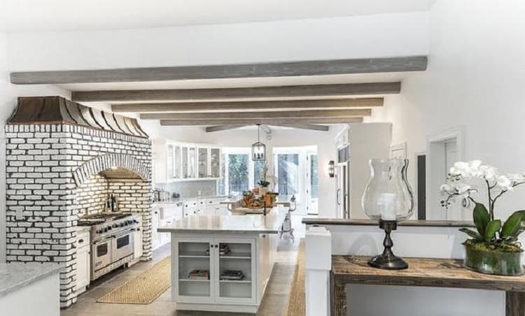 side-view of Selena Gomez's kitchen, showing the kitchen island, stoves and brick decor. 