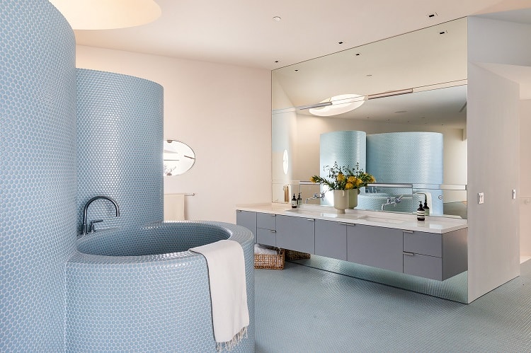 unique bathroom with a blue curved penny-tiled wall