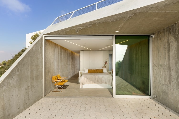 bedroom with a wall of glass that opens out to a terrace 