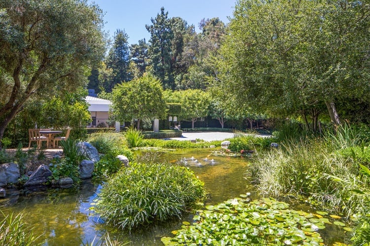 The impressive property has manicured lawns, gardens and dining areas, as well as a reflecting pond and swimming pool.