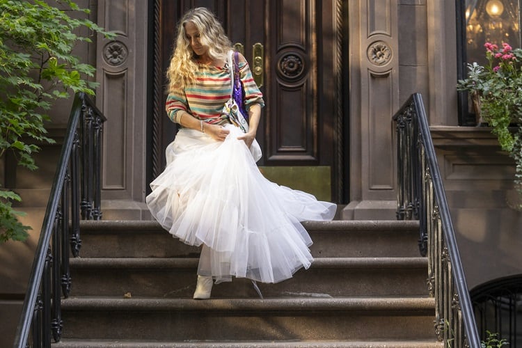 Carrie Bradshaw stepping out of her apartment in the Sex and The City sequel, And Just Like That