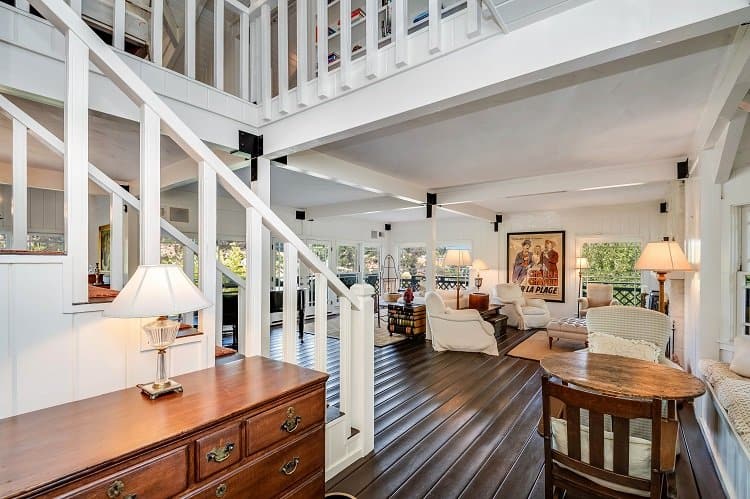 rustic inspired living room with white wooden beams and stairs 