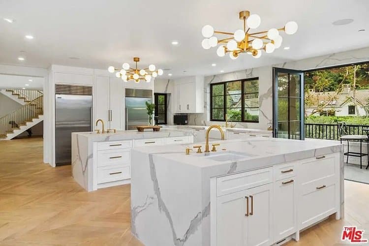 The luxury kitchen in Rihanna's house in Beverly Hills, with two matching marble islands and sleek brass fixtures