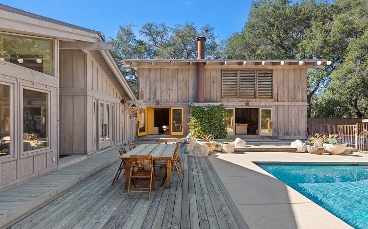 exterior of a midcentury home and barn with a pool