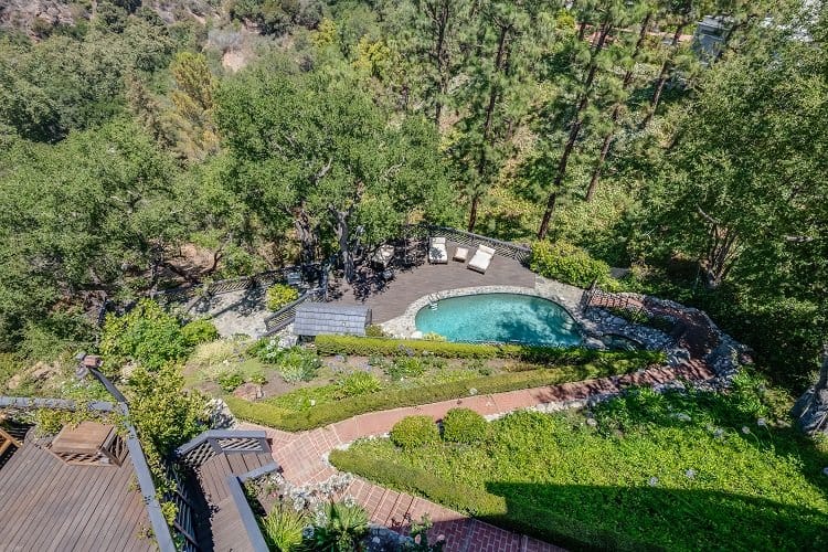 view of the pool and lush landscaped grounds of the property