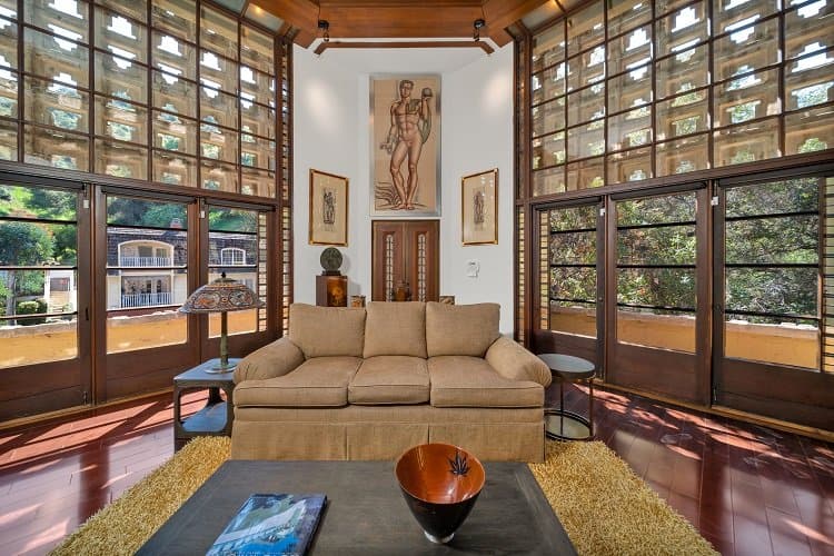 sofa surrounded by floor-to-ceiling glass windows inside the Derby House