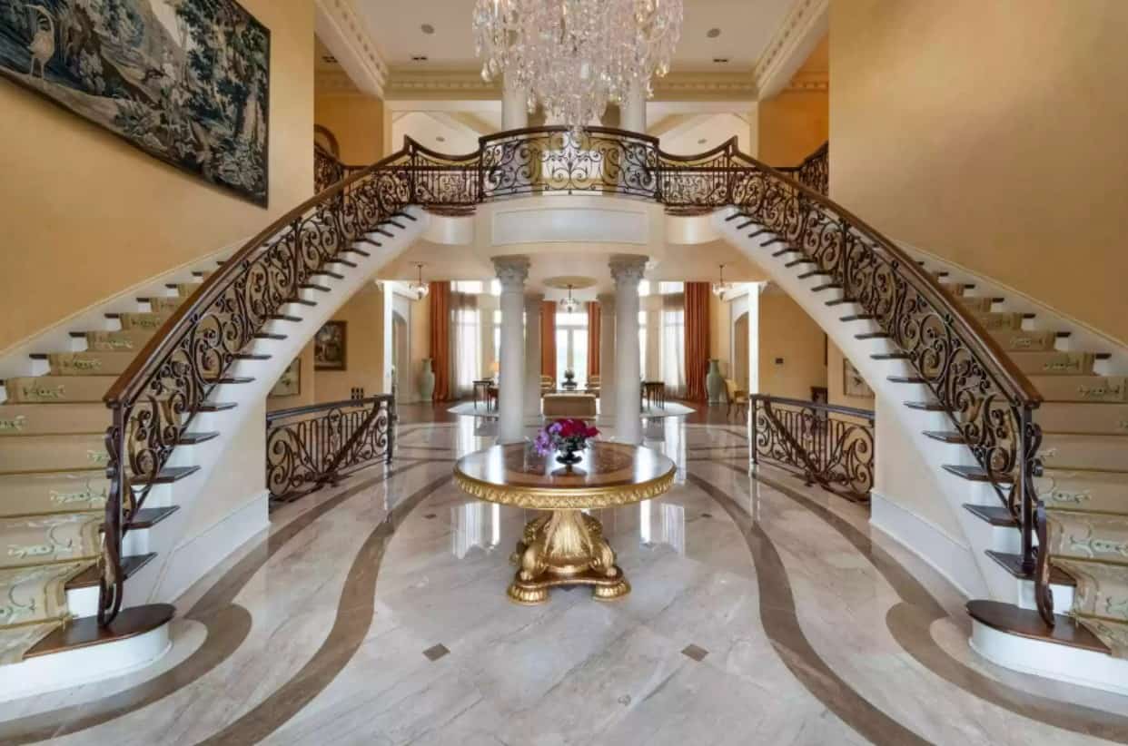 The opulent double staircase welcoming residents and guests as soon as they step foot the Family Feud host's mansion