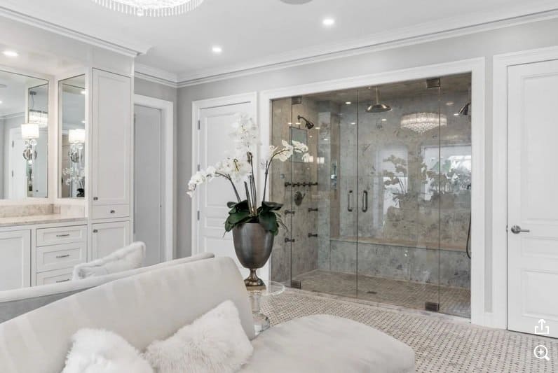 Elegant bathroom with seating area and walk-in shower. 