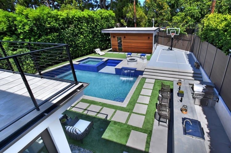 large outdoor area with a pool, spa, waterfall, basketball court and bbq area 