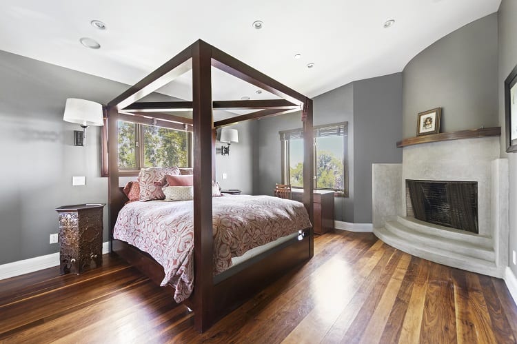 small bedroom with four-poster bed and stone fireplace