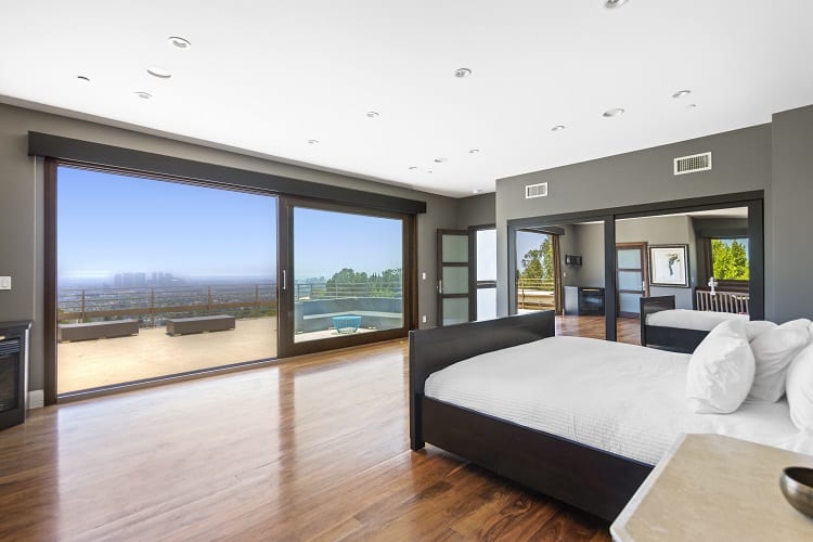 large bedroom with sliding glass doors opening to the balcony