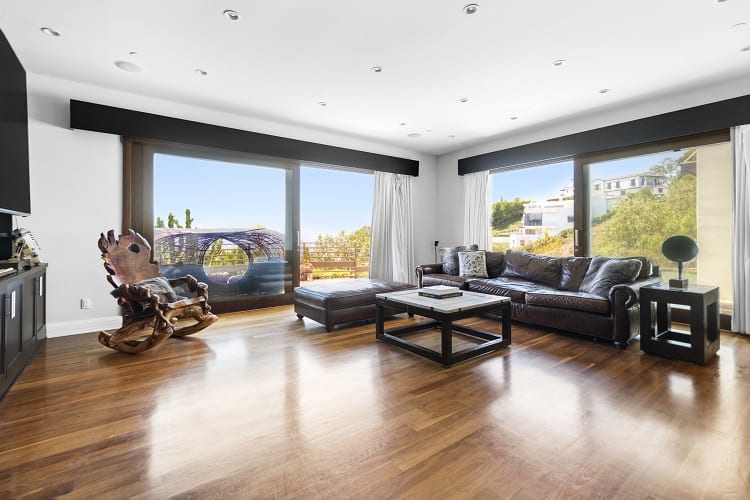 large living room with hardwood floors and floor-to-ceiling windows