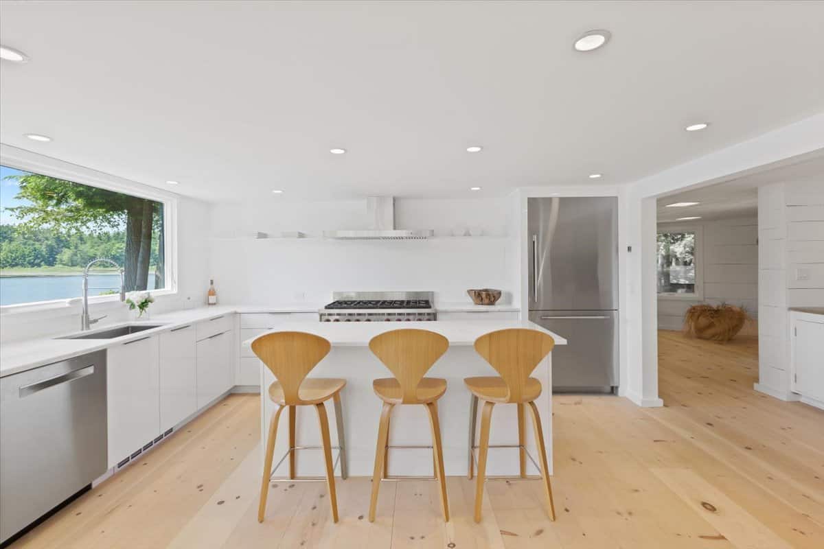 bright kitchen inside the cottage with white walls and warm wood floors